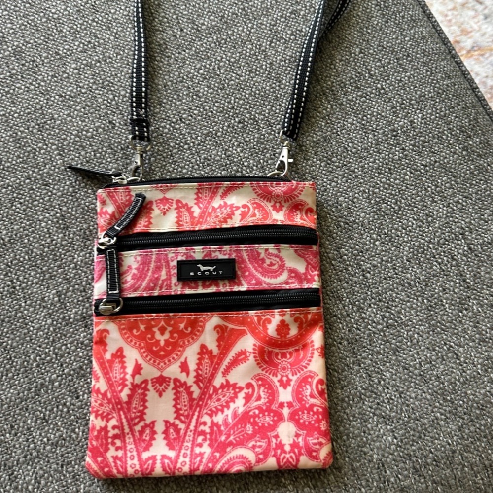 This is a SCOUT Sally Go Lightly crossbody bag featuring a pink and white  EUC